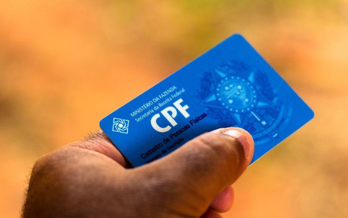 Imagem de uma mão segurando um cartão do CPF