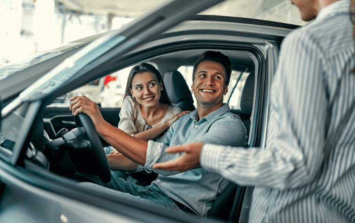 Imagem de um homem e uma mulher dentro de um carro para adquirir o consórcio de carros.